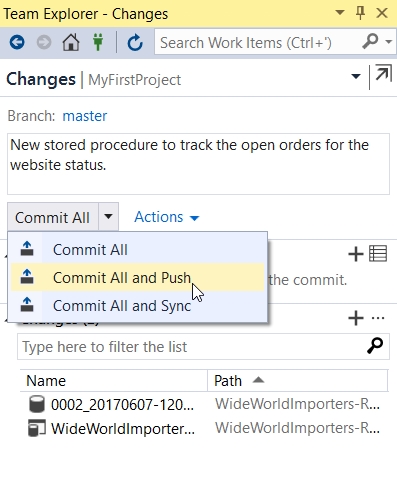 In Team Explorer – Changes, the commit message reads “New stored procedure to track the open orders for the website status.” The Commit All drop-down menu is expanded, and Commit All and Push is selected.